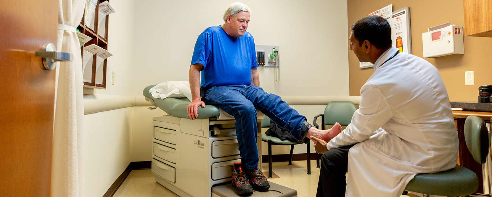 Older adult patient receives a foot exam by a doctor.